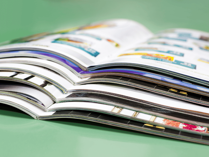 Zu sehen sind verschiedene offene Magazine auf einem grünen Hintergrund.