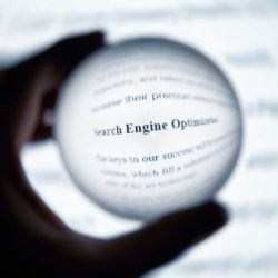 SEO-ITLOGWARE Zu sehen ist ein Vergrößerungsglas mit dem Schriftzug Suchmaschinenoptimierung.